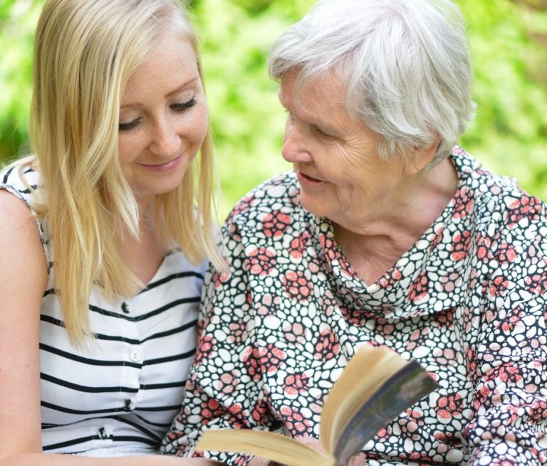 Andreas Bertram Auftragsgedicht Familie Oma Oma hält Buch in der Gedichtband in der Hand und Tochter schaut in das Buch.